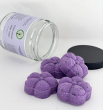Load image into Gallery viewer, Close up of Relaxing Lavender Shower Steamers spilling from jar with black lid next to them