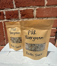 Load image into Gallery viewer, 3.5 oz Bath soak in paper packaging. This picture shows 2 packages together on a white box with brick behind them. Ingredients include mix of sea salts, coconut oil, rosehip oil, coco butter, apricot oil, fankincense oil, lavendar oil, rose petals, chamomile flowers, and lavendar flowers. This soothing mix is perfect for bath time relaxation. 