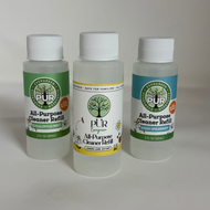 Three bottles of PUR Energy All-Purpose Cleaner Refill arranged on a light gray surface against a neutral light gray background. The left bottle is Espalgipps Mint, the center bottle is Lemon Lime (clear liquid), and the right bottle is Spearmint.